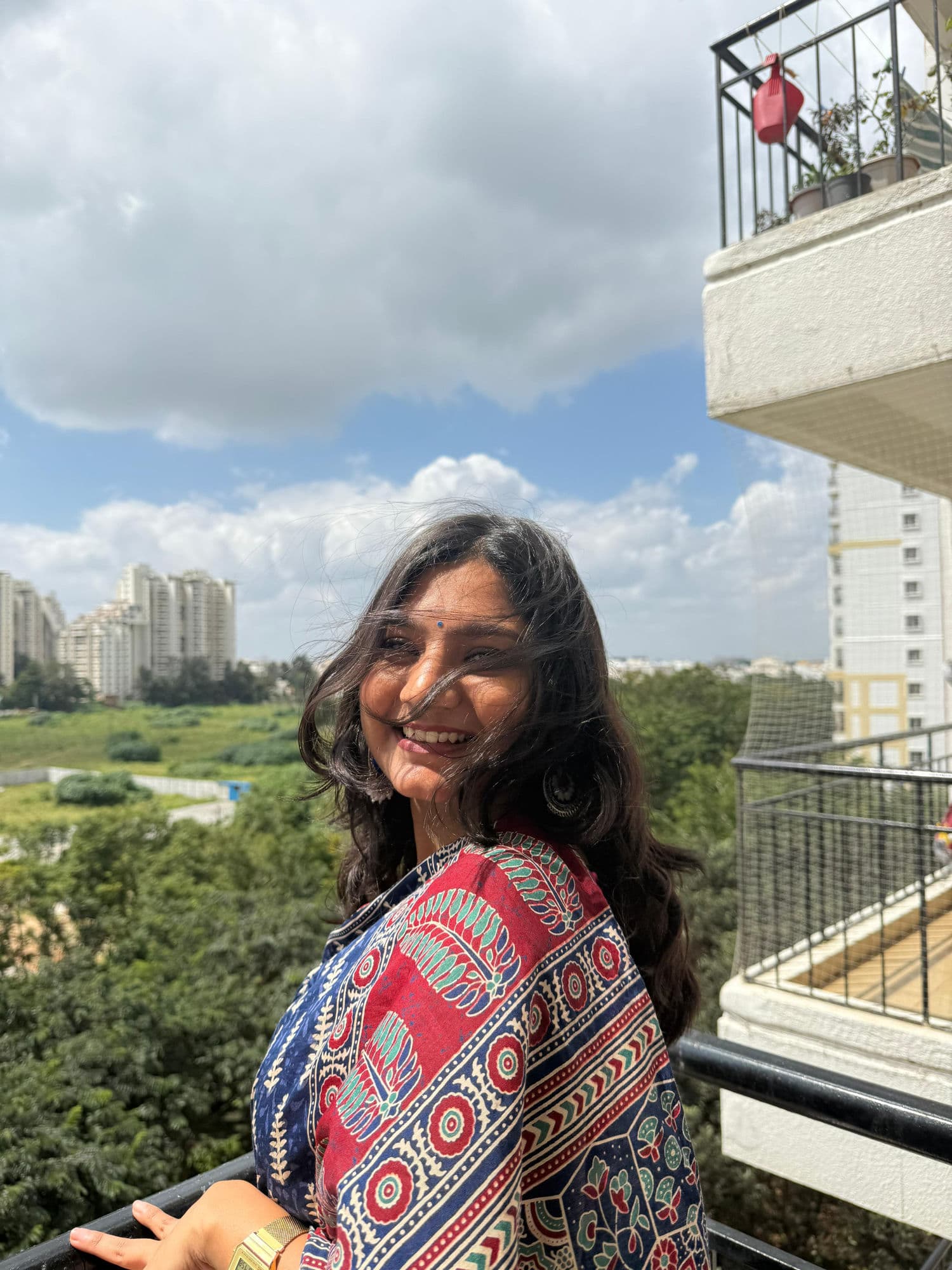 Riya Karan smiling on a balcony overlooking Bangalore